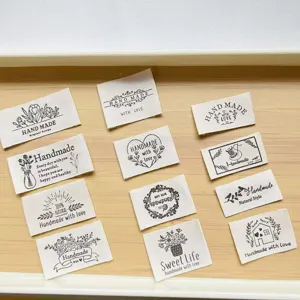 Handmade fabric labels with cute floral text patterns, perfect for DIY sewing clothing and crafts.