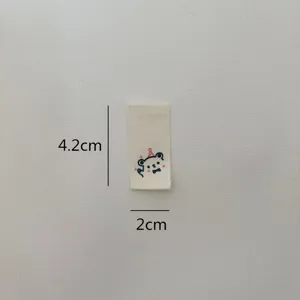 Detail view of a cute cartoon bear folded woven label, perfect for hats, socks, and garments.