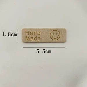 Handcrafted leather label patch with handmade text and smiley face design for DIY crafts
