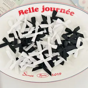 Close-up detail of mini black and white ribbon bows, perfect for handmade DIY crafts and decor.
