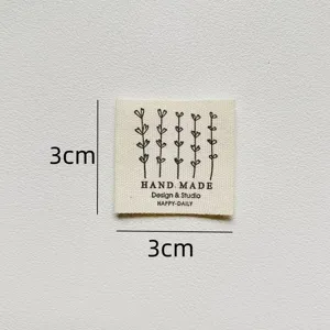 Detail view of handmade cotton clothing label with flower pattern, size 3x3cm, ideal for DIY crafts.
