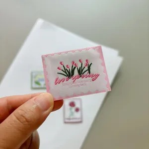 Tulip embroidered woven label patch, cute floral stamp design for DIY handmade fashion crafts.