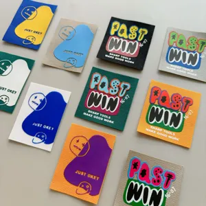 Detailed shot of trendy clothing patches, colorful letter graffiti designs, garment decorations.