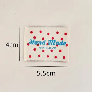 Handmade woven cloth label with red polka dots and lovely blue embroidery text for sewing.