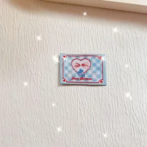Embroidered fabric patch detail with blue plaid pattern and cute pink heart design for DIY.