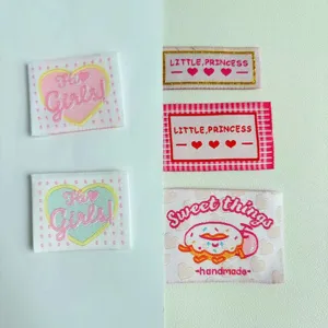 Close-up detail shot of cute embroidered fabric labels with heart and donut designs for sewing.