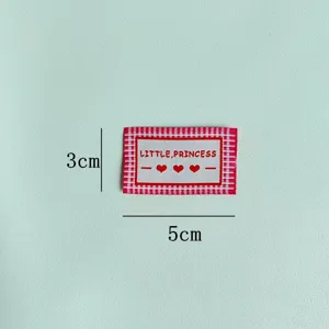 Woven label detail, red and white check pattern, 3x5cm garment accessory patch.