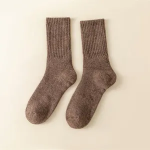 Detailed shot of brown wool winter thermal mid-calf socks with ribbed cuffs and cozy fabric.