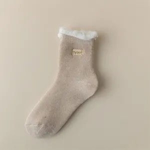 Cozy fleece-lined mid-calf sock detail showing soft plush cuff and cute stitched label.
