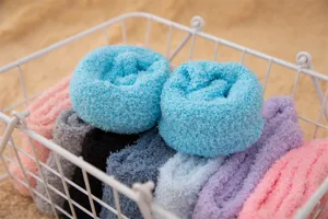 Gros plan de chaussettes douces en polaire corail roulées dans un panier fil de fer.