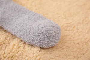 Détail de chaussettes en molleton corail gris doux montrant la texture moelleuse.