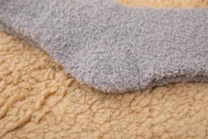Gros plan detaille des chaussettes de sommeil en polaire grise avec une texture pelucheuse douce.
