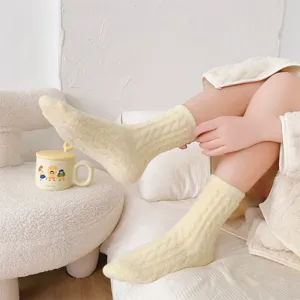 Detail view of plush cable knit mid-calf warm socks in soft yellow color for cozy indoor winter wear.