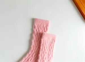 Pink fuzzy cable knit winter socks detail close up, warm thick thermal sleep hosiery.