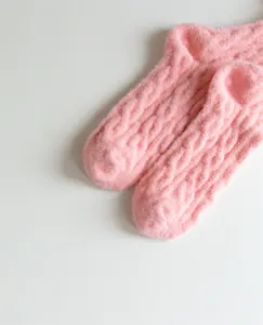 Pink fuzzy cable knit socks detail shot, soft plush warm winter cozy home socks for women.