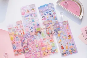 Close-up details of dreamy resin epoxy puffy stickers featuring cute space cats and sweet desserts.