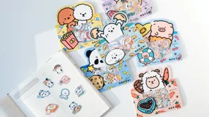Cute cartoon animal sticker packs detail shot showing pandas, pigs, and sheep on white table.