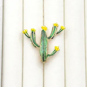 Detailed view of exquisite cactus enamel brooch pin, featuring vibrant green and yellow details.