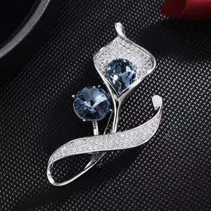 Élégante broche lys calla ornée de zircons bleus scintillants pour manteaux et costumes.