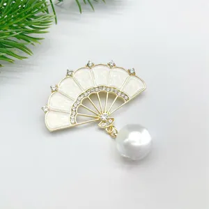 Detailansicht einer Vintage chinesischen Fächerbrosche mit weißem Emaille, Strass und Perle.