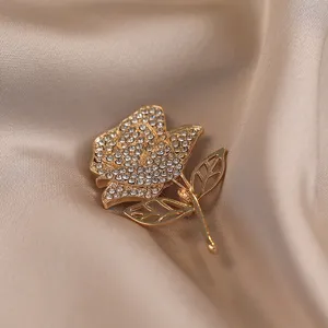Exquisite rhinestone rose brooch featuring detailed gold metal leaves for elegant coat lapels.