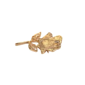 Detailed view of gold rose brooch back pin metal fastener accessory winter coat jewelry