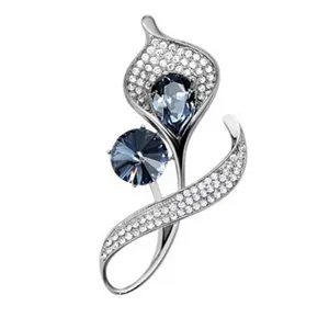 Vue détaillée d'une broche florale argentée avec des cristaux clairs et des pierres bleues.