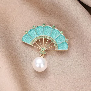 Nahaufnahme einer chinesischen Fächer-Brosche mit Emaille, grünen Strasssteinen und Perle.