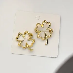 Golden four leaf clover brooch pin, minimalist chic fashion lapel badge accessory for women.