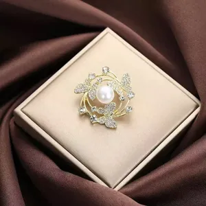 Exquisite Korean style pearl butterfly brooch detail, shiny rhinestone gold tone suit pin accessory.