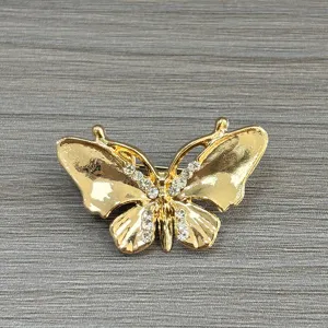 Exquisite close-up detail of the gold butterfly brooch, featuring sparkling rhinestone accents.