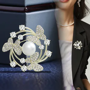 Close-up detail of the elegant butterfly pearl brooch pinned on a black suit, shiny rhinestones.