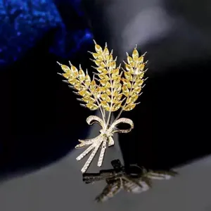 Exquisite close-up view of golden wheat brooch showcasing sparkling yellow crystals and bow.