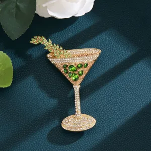Detailed view of a sparkling crystal cocktail glass brooch featuring green and white rhinestones.