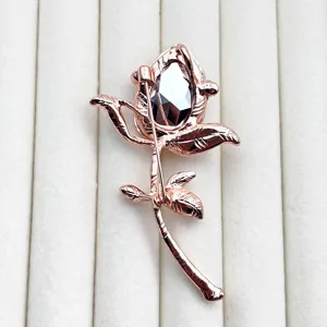 Detailed close-up view of the rose brooch back, showcasing pin structure and crystal.