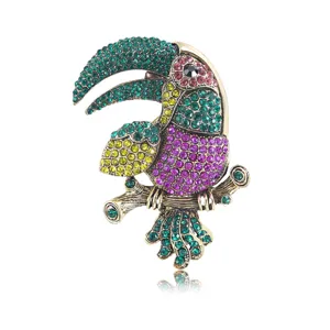 Detailed close-up of the sparkling rhinestone toucan brooch, showing vibrant crystal inlay.