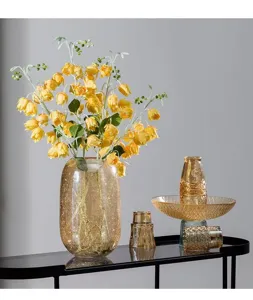 Detailed view of the large amber glass vase with crackle texture and vibrant yellow flowers.