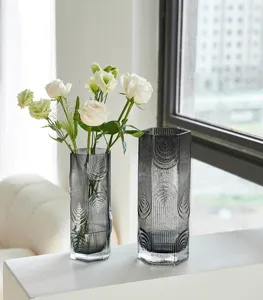 Moderno vaso in vetro grigio con motivo scanalato geometrico per arredare casa.