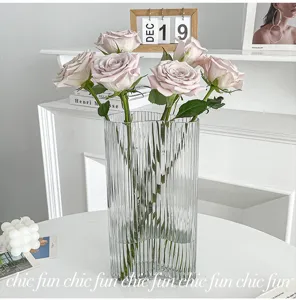 Transparent ribbed glass vase with fluted design and elegant wave rim, for home decor.