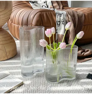 Transparent glass wavy flower vase for living room decor, modern minimalist table centerpiece.