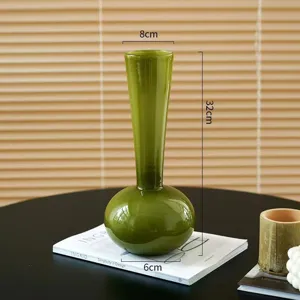 Detailansicht der eleganten grünen Glasvase, die ihre einzigartige Form und glatte Oberfläche zeigt.