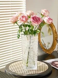 Clear glass vase with elegant vertical texture, ideal for holding beautiful fresh pink roses.