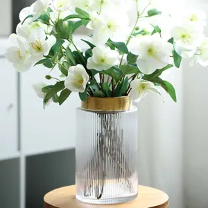 European style ribbed glass vase with gold metal ring and white artificial flower bouquet.