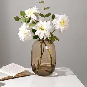 Jarrón de vidrio marrón transparente con flores blancas y hojas verdes para el hogar