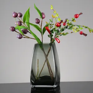 Rauchgraue Glasvase mit künstlichen Beerenweigen, moderne minimalistische Heimdekoration.
