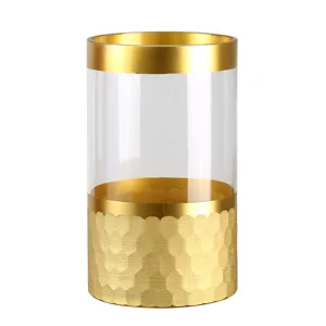 Modern transparent glass vase with gold rim and textured base for home decor and tabletop.