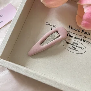 Close-up detail van een roze stoffen haarclip, stijlvolle haaraccessoire voor dames.