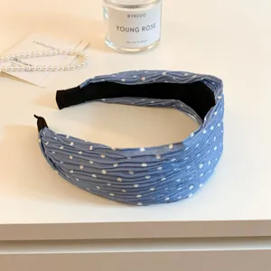 Close-up detail shot of the blue pleated polka dot headband, featuring a wide fashion hair hoop.