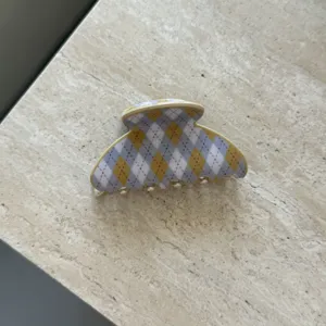 Nahaufnahme der schicken Acetat-Haarklammer mit Argyle-Muster und feiner Detailstruktur.