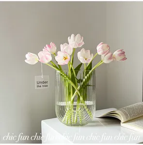 Vase en verre transparent nordique à rayures verticales et tulipes roses, déco élégante.